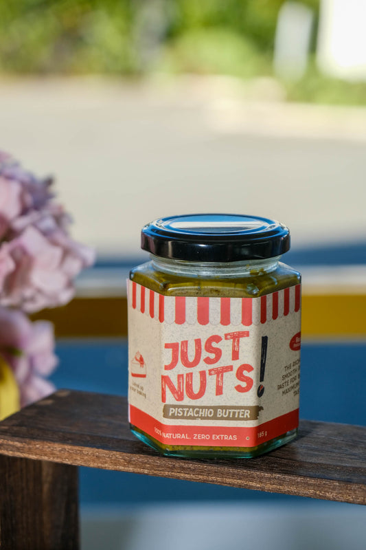 Jar of 'Just Nuts!' pistachio butter on a wooden surface made in christchurch, pure pistachio 100%